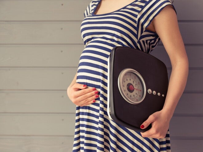 Pregnant woman with weighing machine Pregnant woman with weighing machine